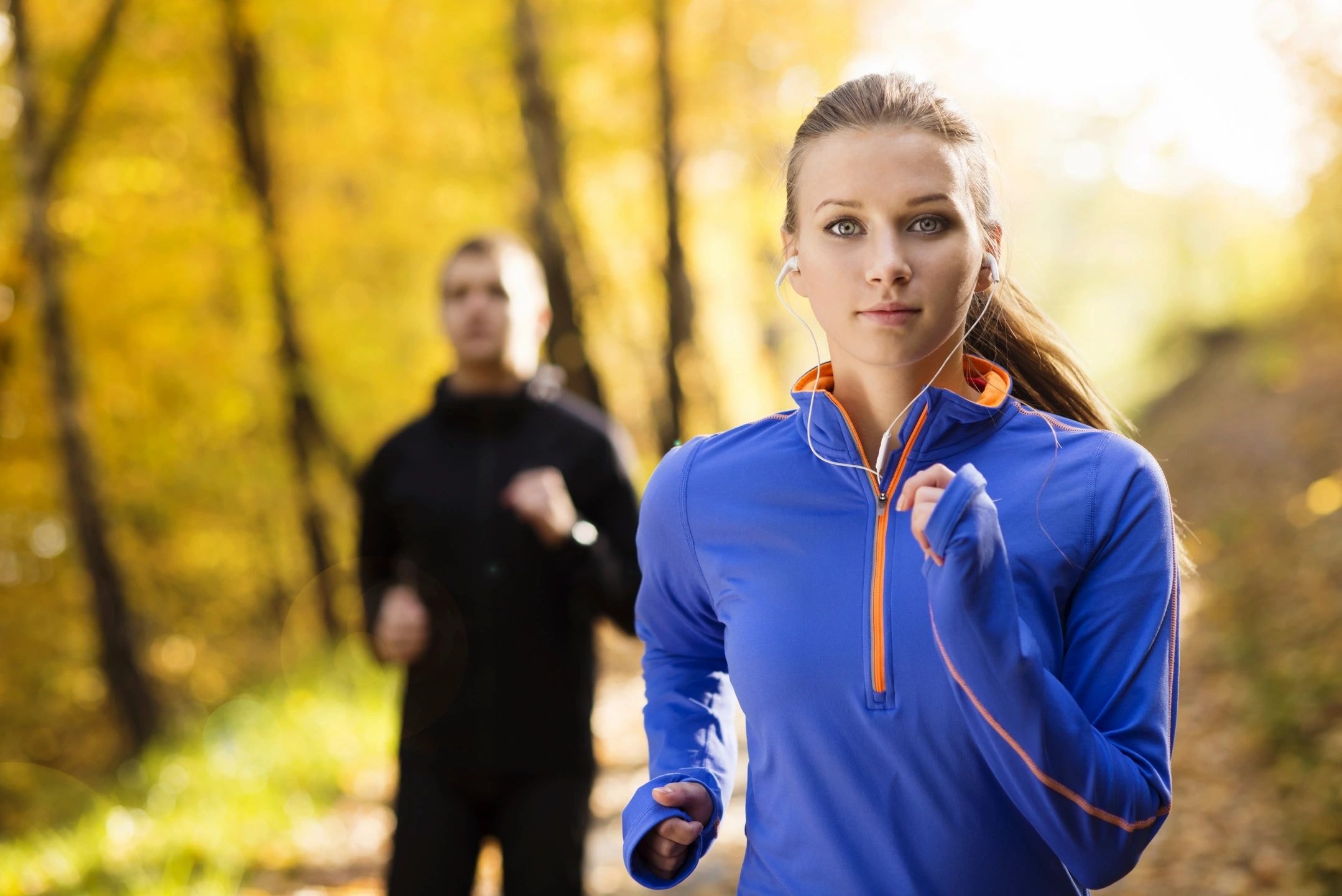 Woman jogging forest path autumn